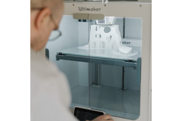 Image Man working on a 3D printer.
